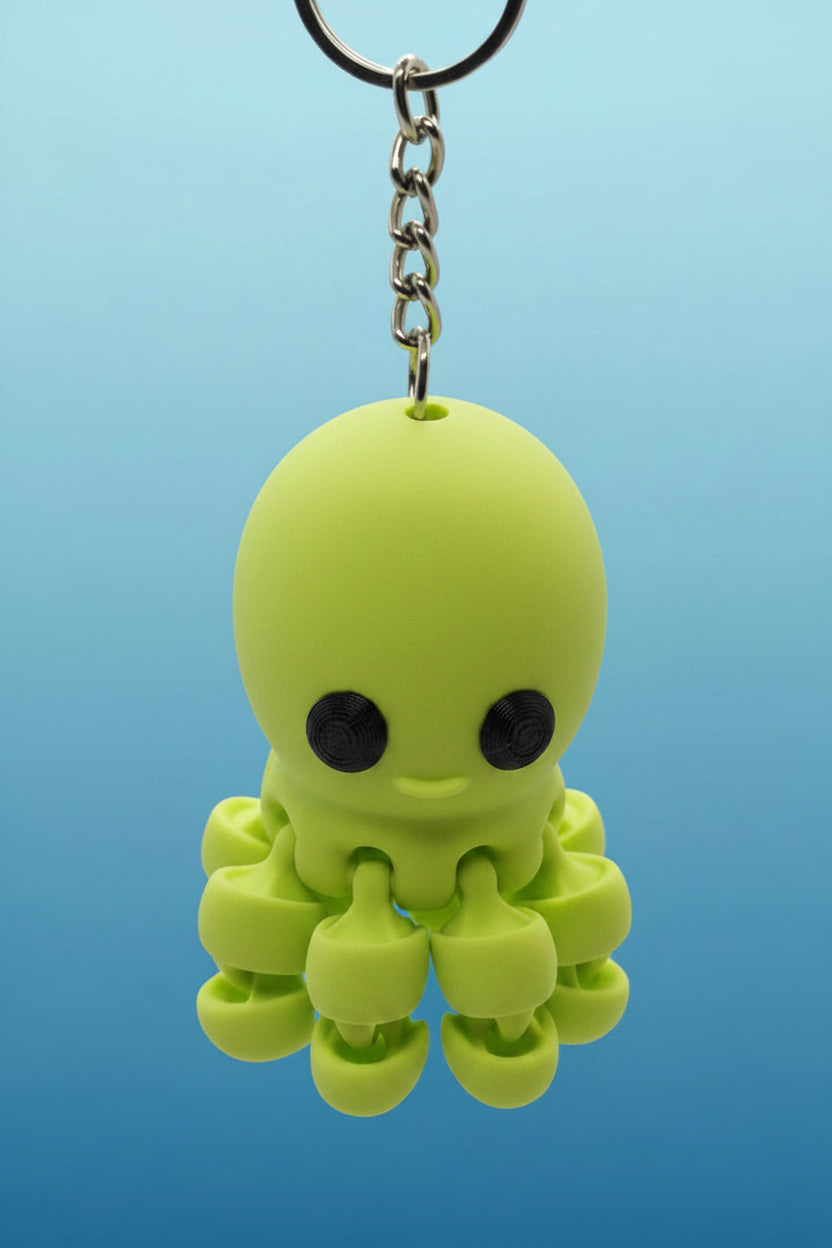 Green octopus-shaped keychain on a blue background