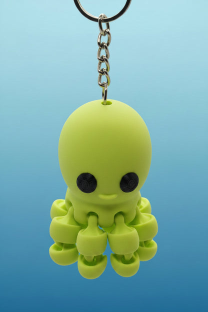 Green octopus-shaped keychain on a blue background