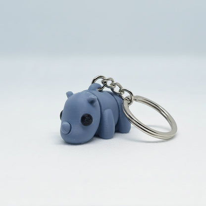 Blue-grey baby rhino-shaped keychain on a white background