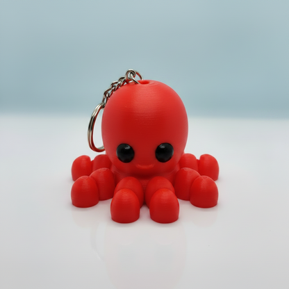 Red octopus-shaped keychain on a light blue white background